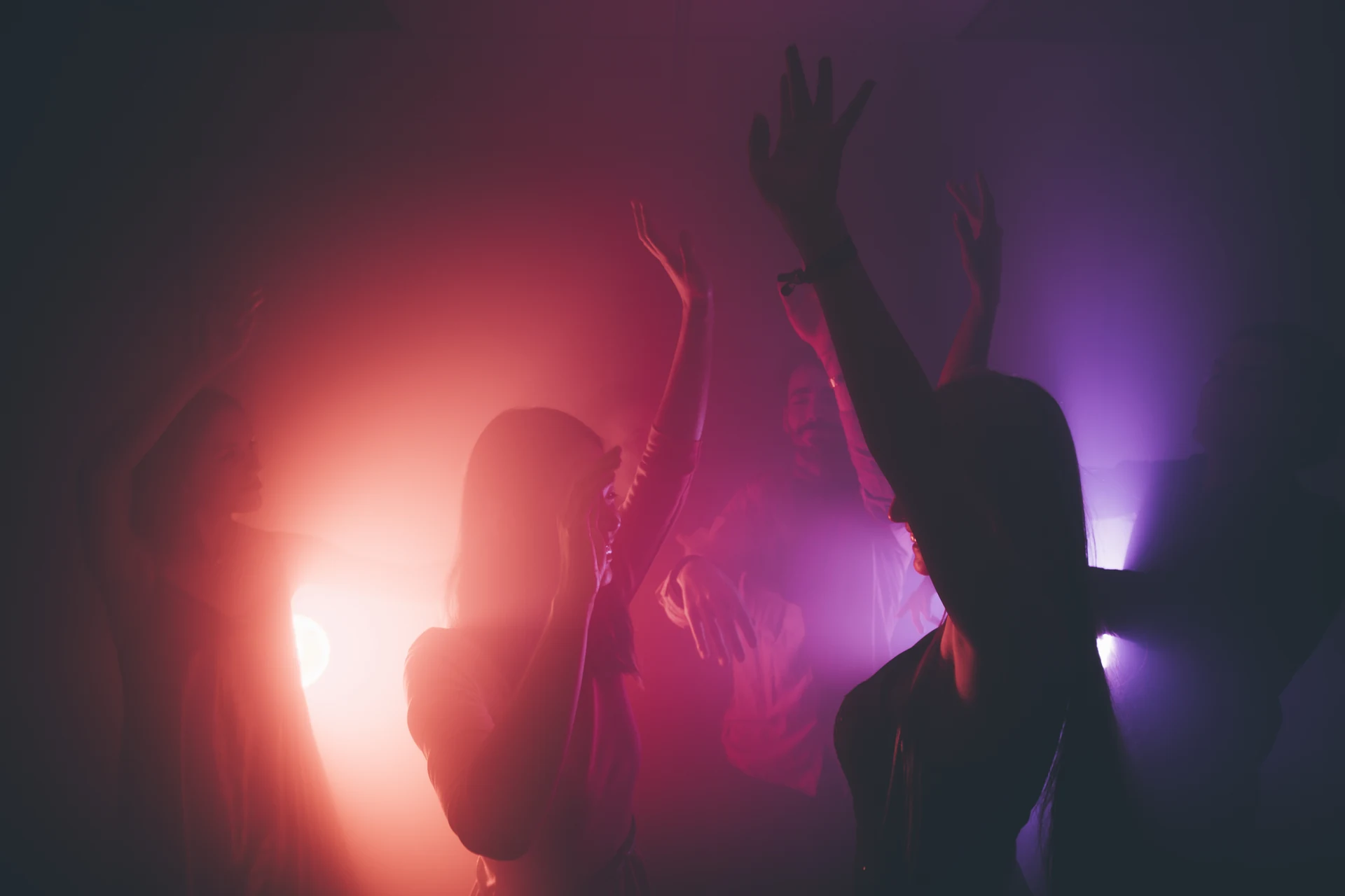 Invitados bailando bajo luces de colores en una fiesta privada